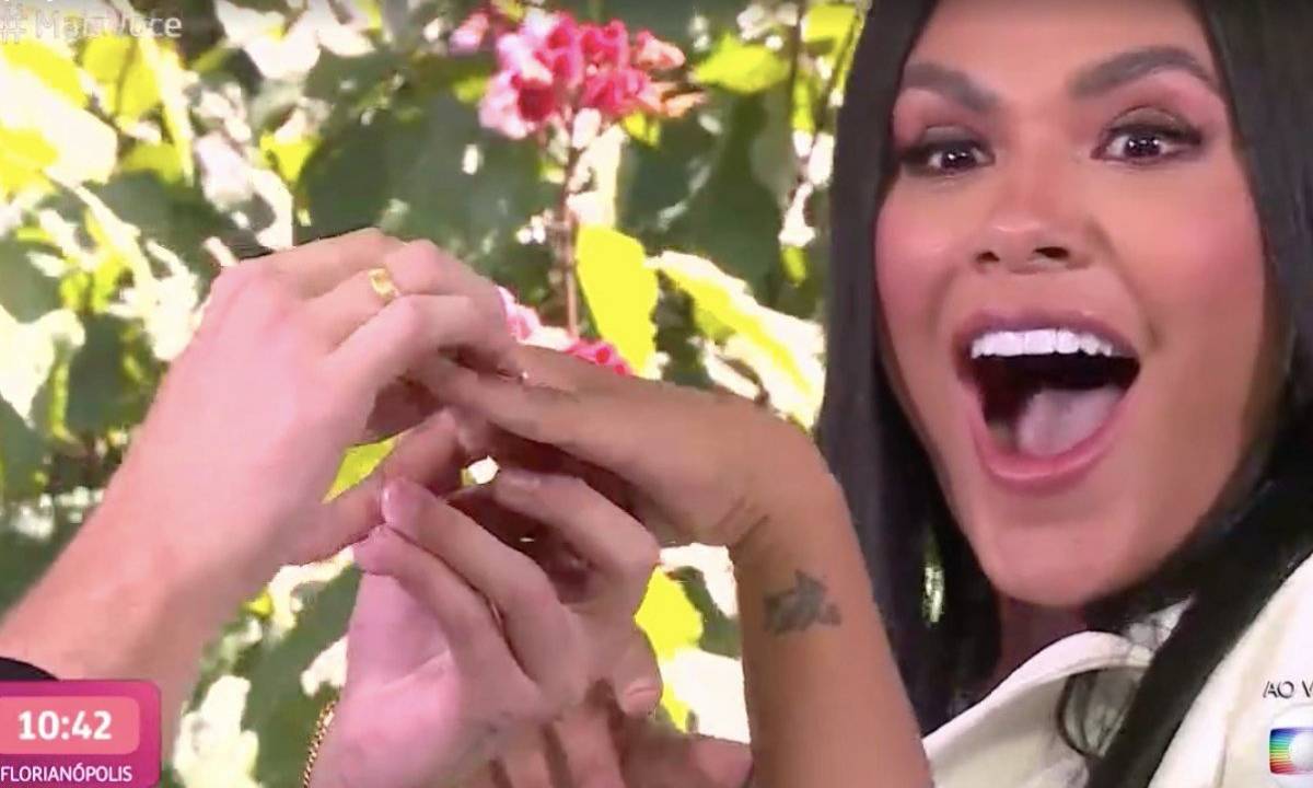 A imagem mostra o moment em que o noivo de Pocah coloca uma aliança em seu dedo, ao vivo, na TV