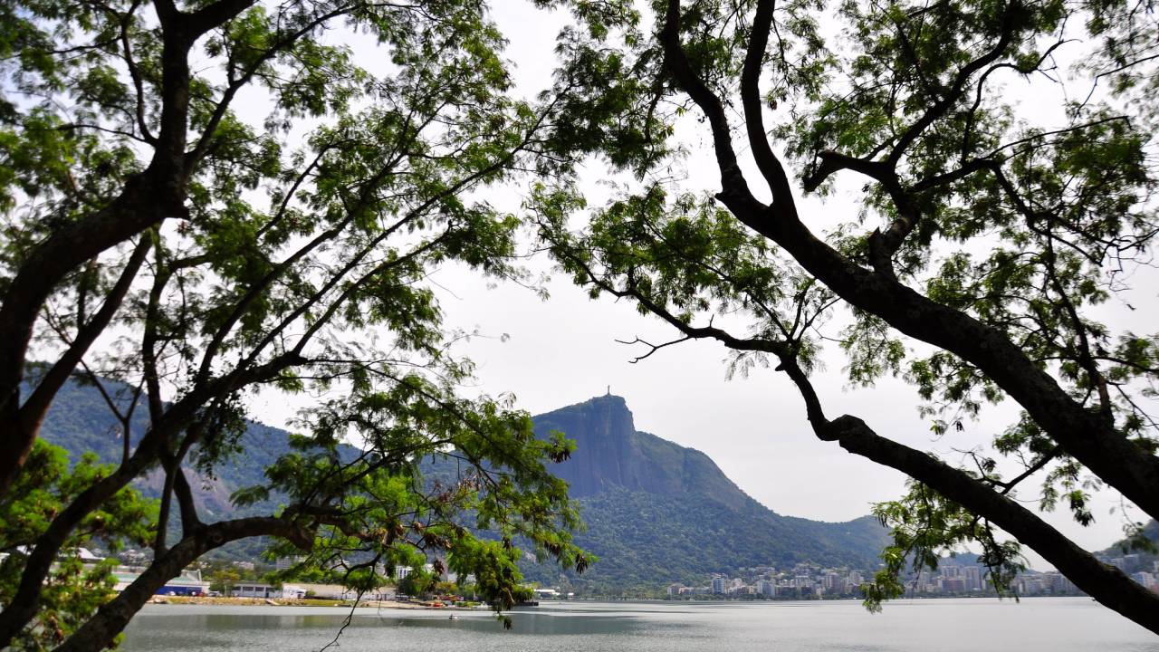 Lagoa Rodrigo de Freitas, com o Cristo em destaque e muitas árvores ao redor