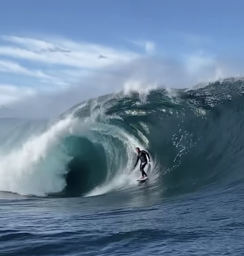 A imagem mostra o surfista Caio Vaz numa onda grande e tubular