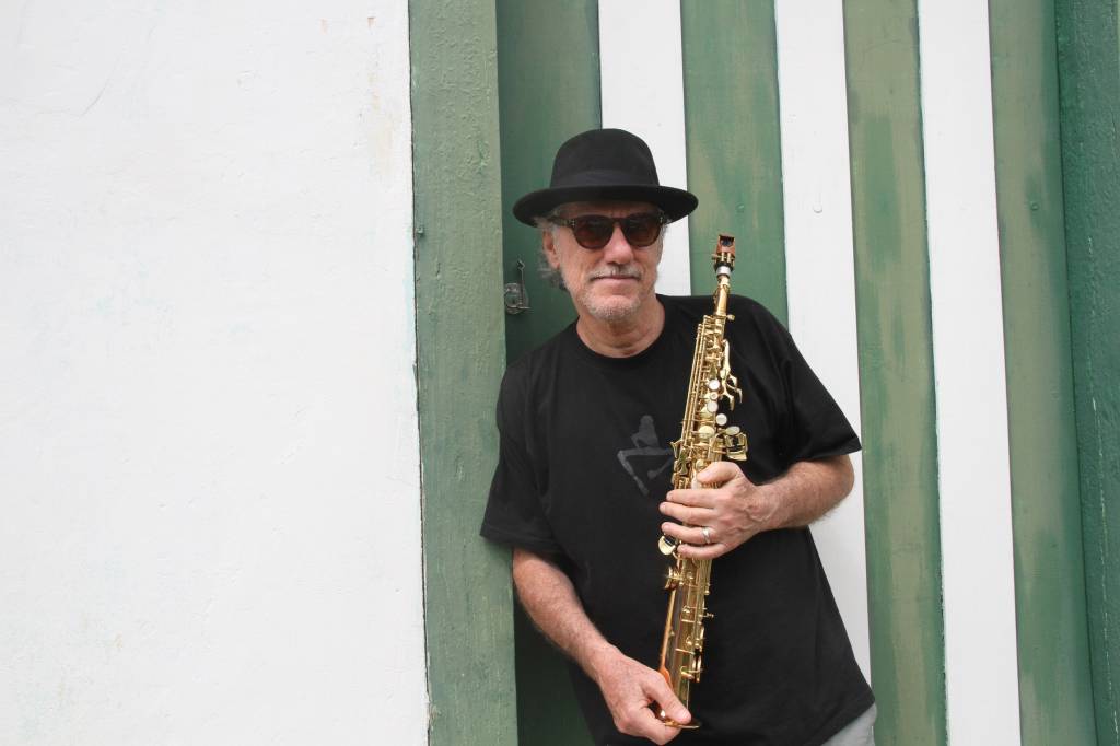 Mauro Senise, encostado numa parede, segurando um clarinete