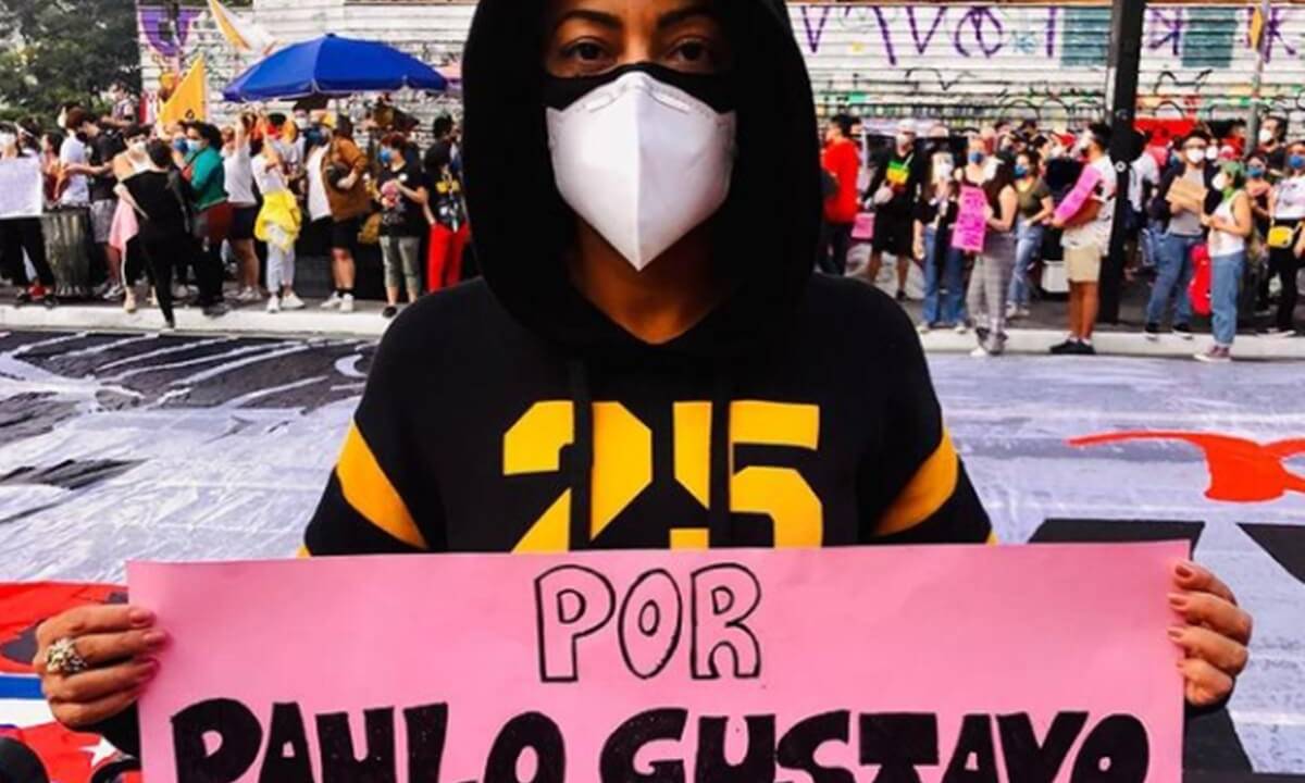 A imagem mostra a atriz Samantha Schmütz segurando um cartaz com o nome de Paulo Gustavo, no meio da manifestação, em São Paulo
