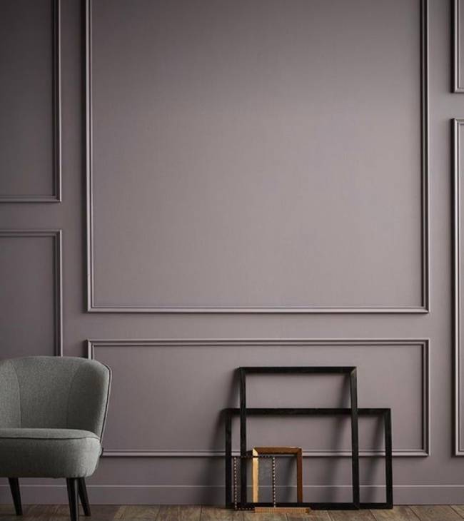 Boiserie moderna A imagem mostra uma parede com boiserie. Em segundo plano uma poltrona.