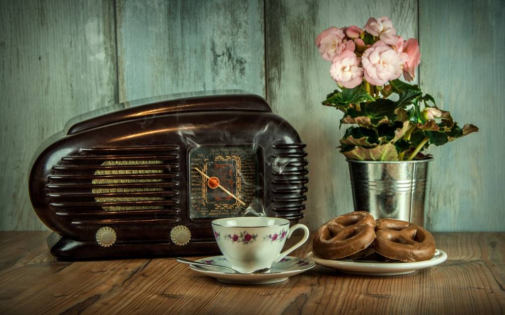 aparelho de rádio antigo com um prato de biscoitos na frente