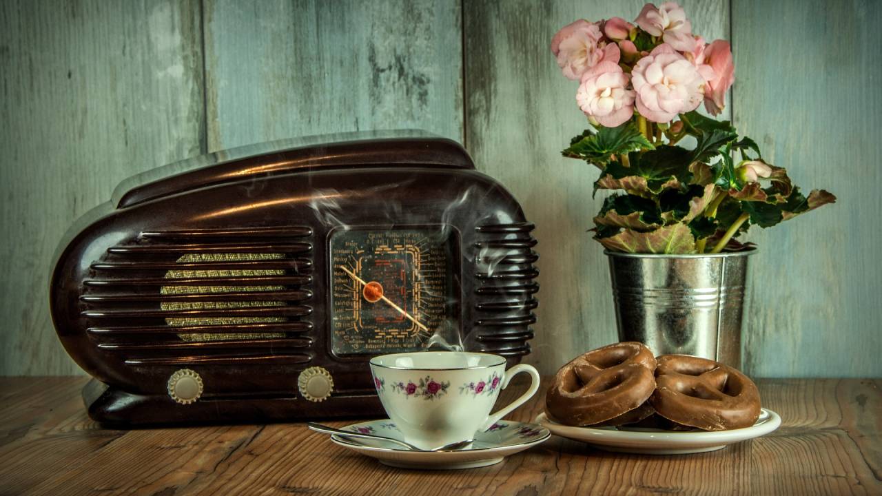 aparelho de rádio antigo com um prato de biscoitos na frente