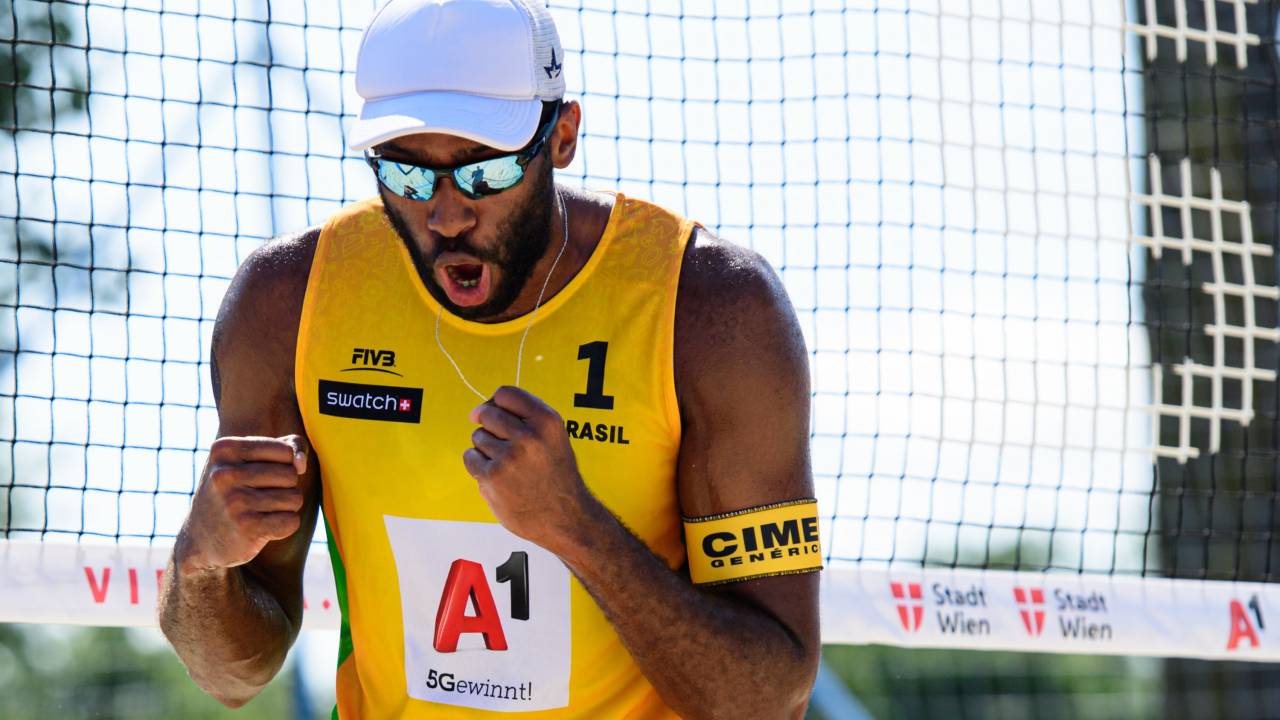 A imagem mostra o atleta Evandro Junior, do volei de praia, comemorando um ponto