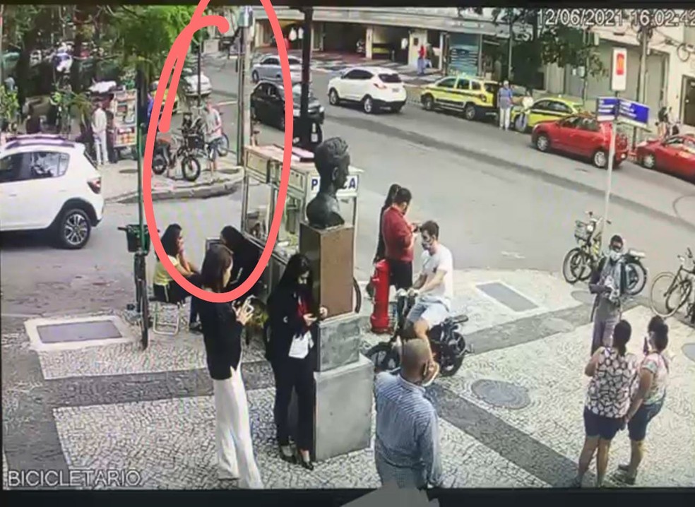 Imagem de câmera de segurança do Shopping Leblon mostra jovem roubando bicicleta ao fundo. Na calçada, muitas pessoas circulando