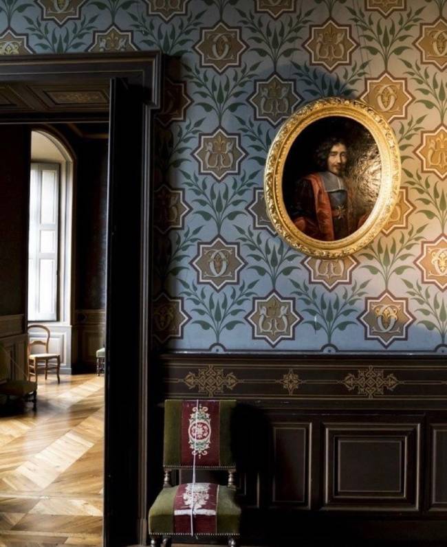 Imagem mostra uma sala no Castelo D' Ancy. Em primeiro plano uma parede com lambri de madeira. Em segundo plano uma cadeira.