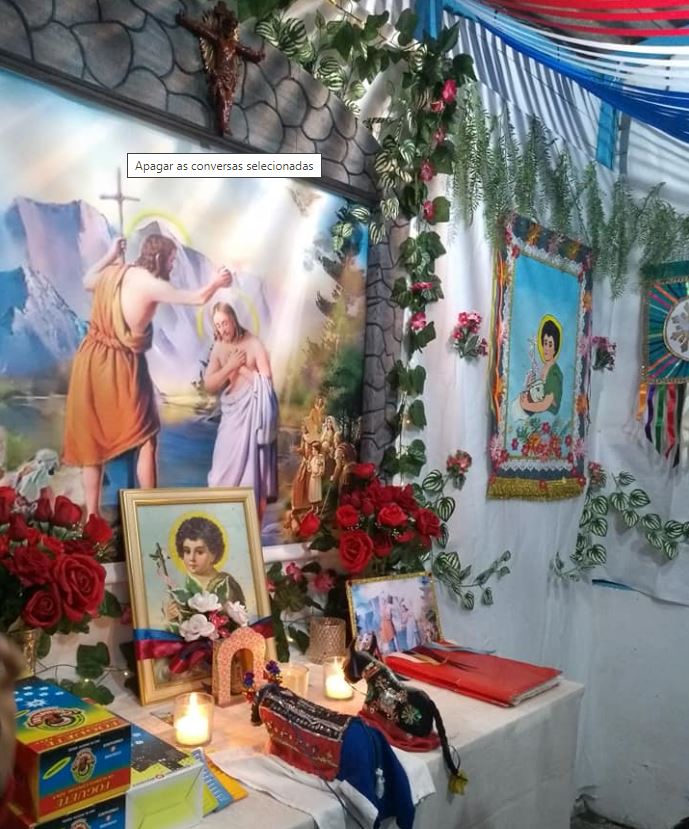 Foto do Altar do Boi Brilhante de Lucas onde aparecem Santo Antônio, velas e flores