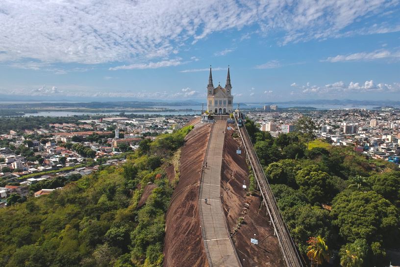 Foto do alto da Igreja da Penha com céu azul e o fundo da Baía de Guanabara