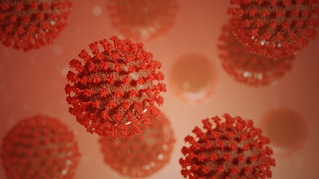 Foto mostra ilustração do coronavírus na cor vermelha