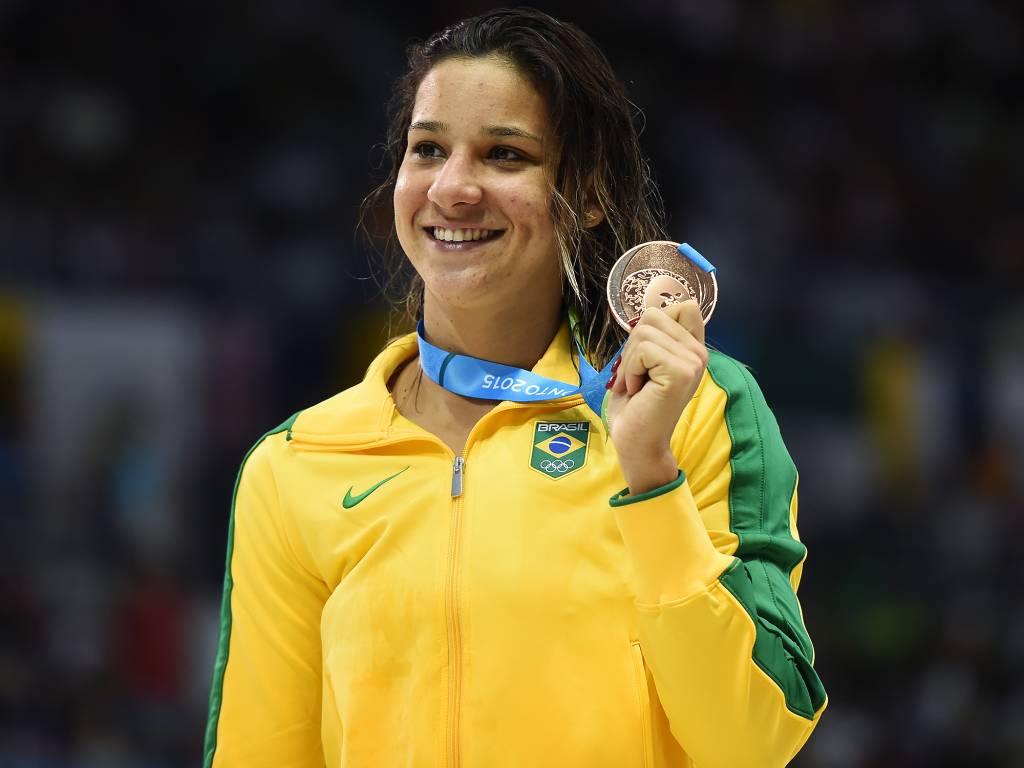 A imagem mostra Joanna Maranhão segurando uma medalha