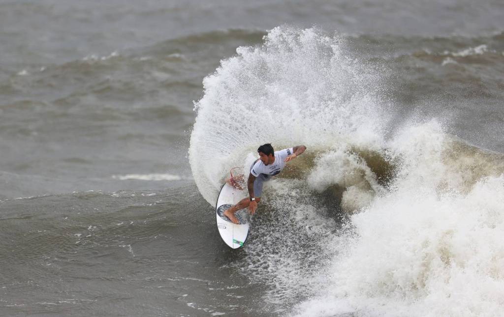 A foto mostra o surfista Gabriel Medina surfando uma onda no Japão