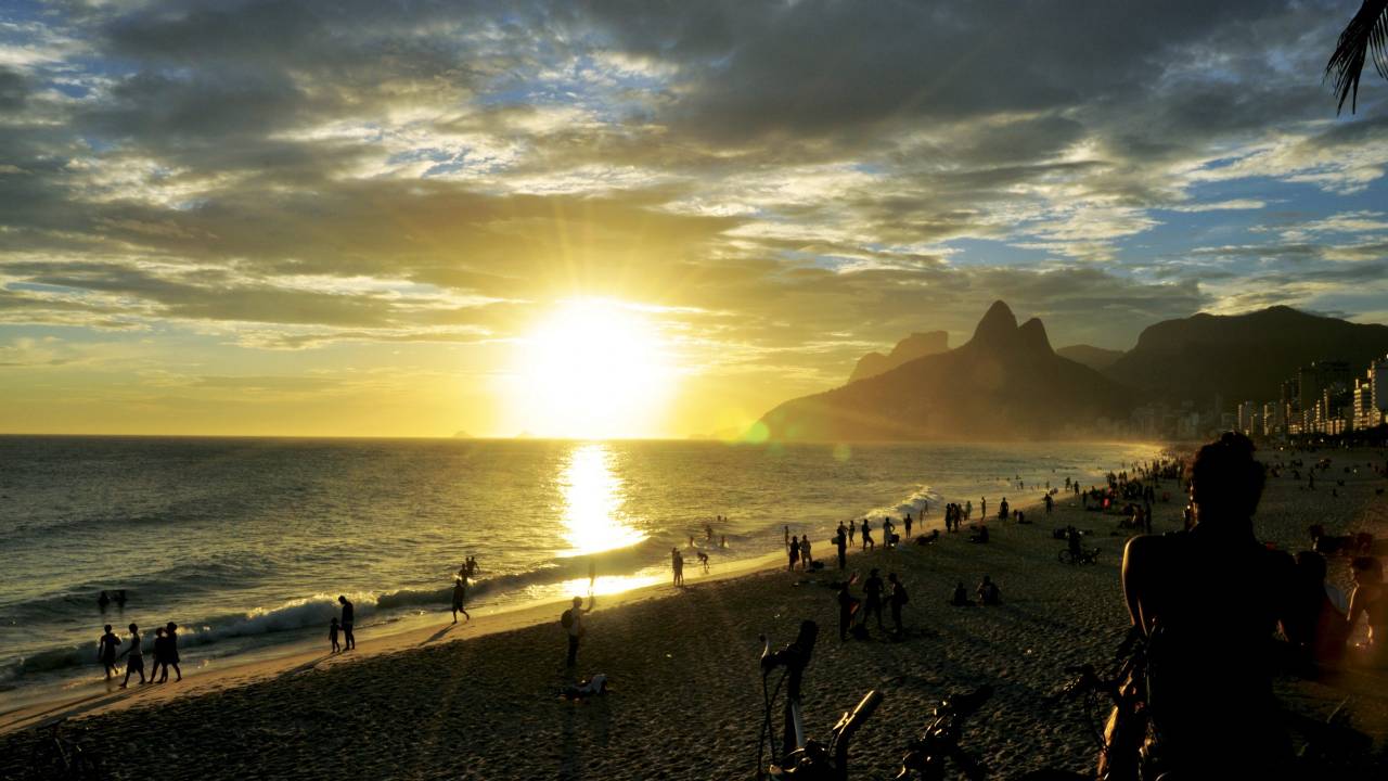 A imagem mostra o por do sol na Praia de Ipanema, visto do Arpoador