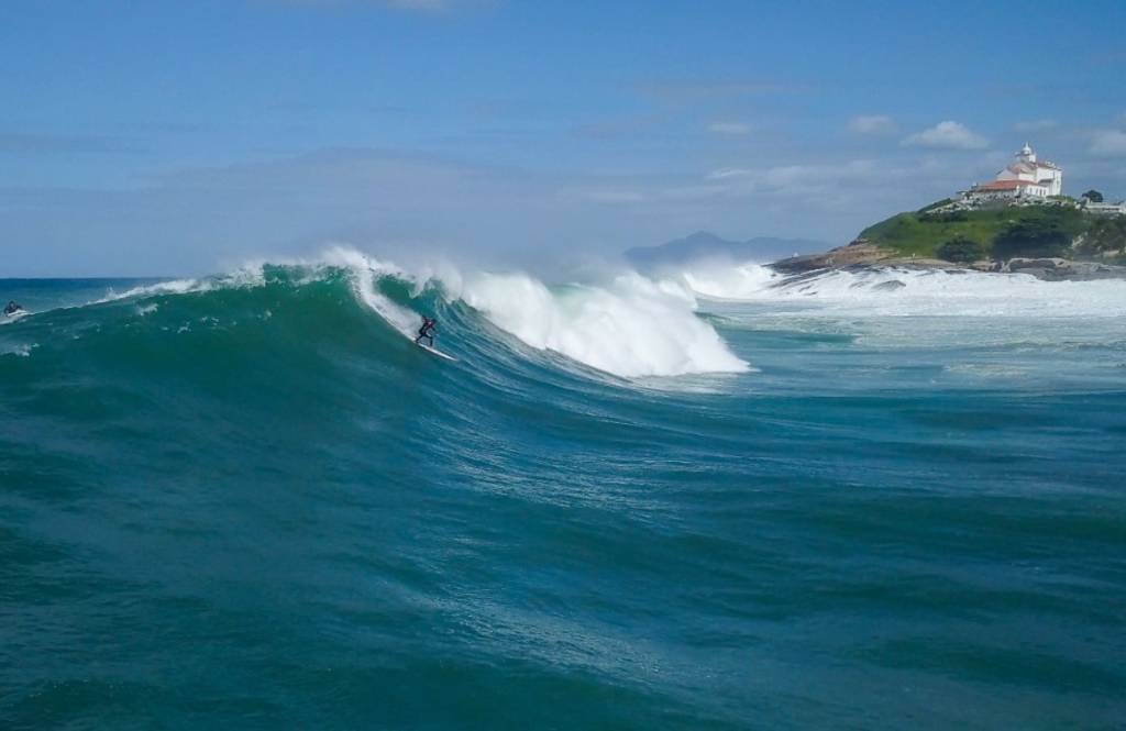 Foto mostra pessoa surfando em uma onda em Saquarema