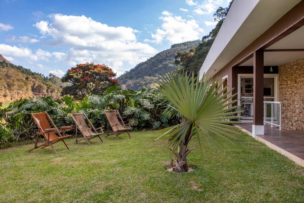 Refúgio familiar no campo conta com décor rústico e cocheira de cavalo