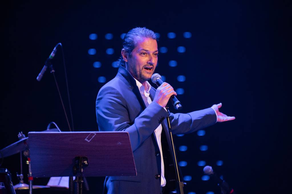 Marcelo Serrado no palco, cantando