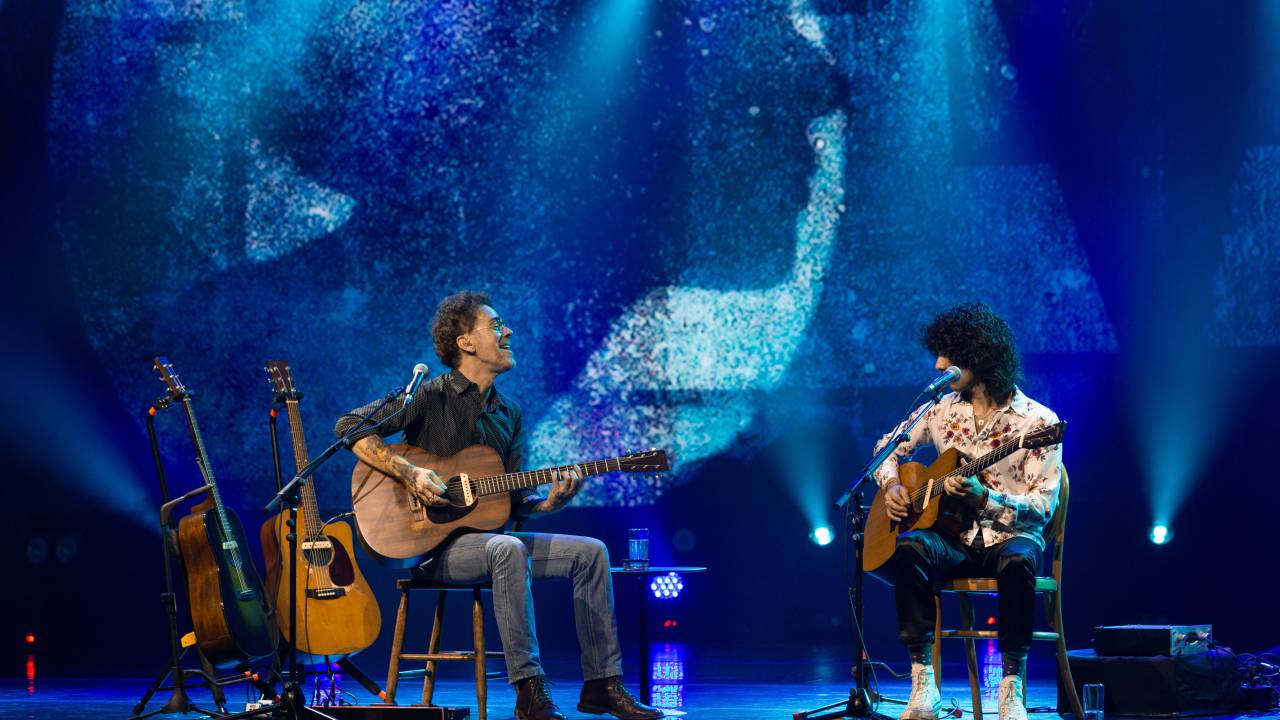 Nando Reis e Sebastião Reis cantando juntos no palco