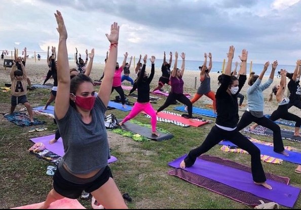Yoga Beach Reprodução-Instagram Imagem mostra grupo de pessoas praticando yoga