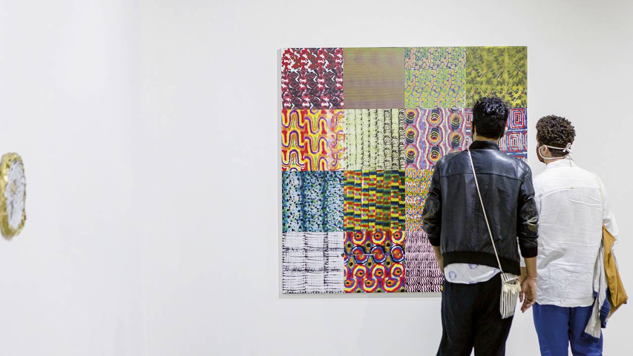 Pintura na parede da ArtRio com pessoas olhando, de costas
