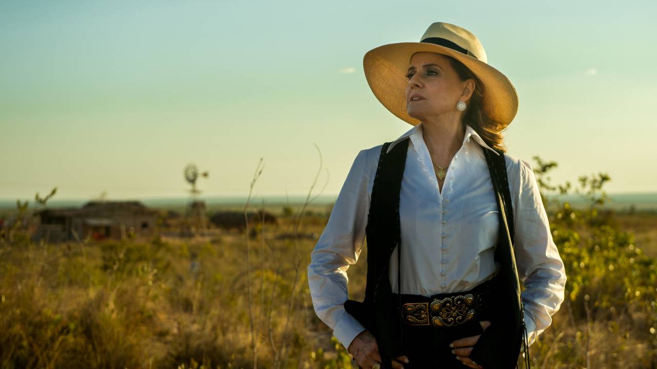 Marieta Severo de chapéu, no campo, olhando para o lado, com altivez