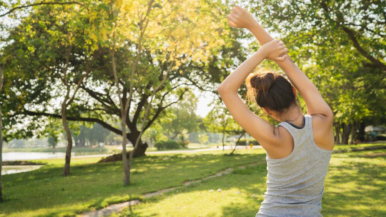 Foto mostra mulher se exercitando ao ar livre