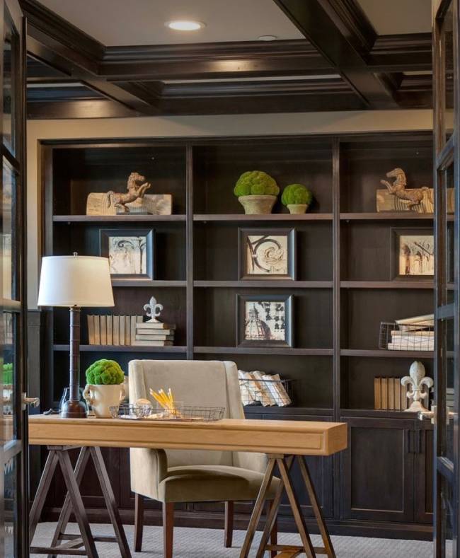 Home Office Imagem mostra um home office. Em primeiro plano uma estante e em segundo plano uma mesa com uma cadeira.