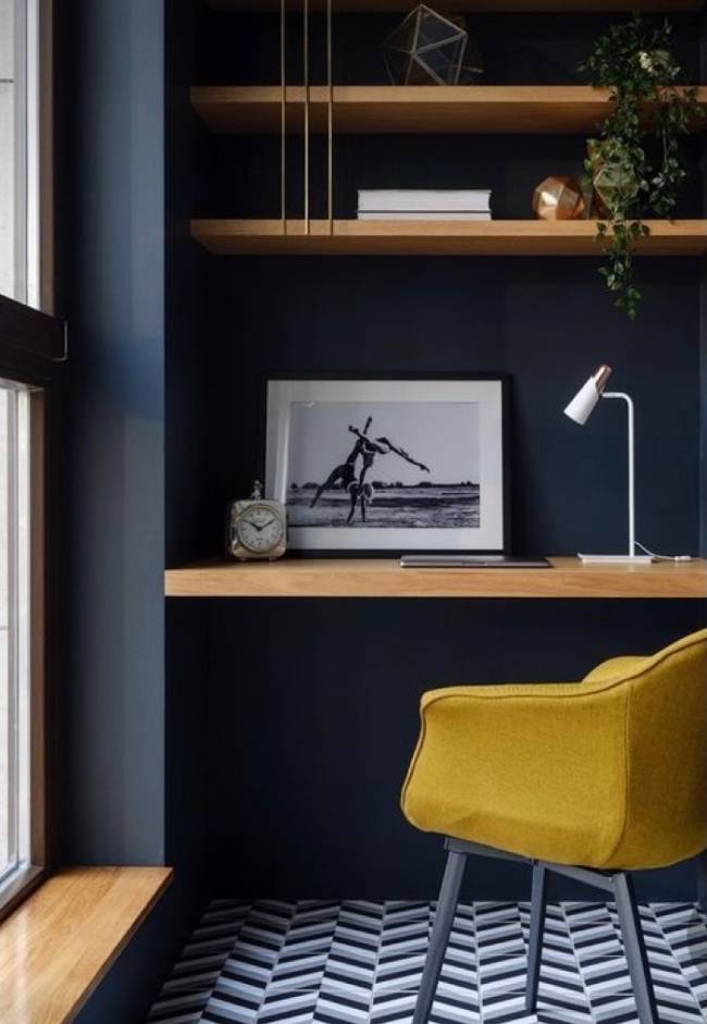Home Office A imagem mostra um pequeno home office com parede azul e em segundo plano uma cadeira com estofado amarelo