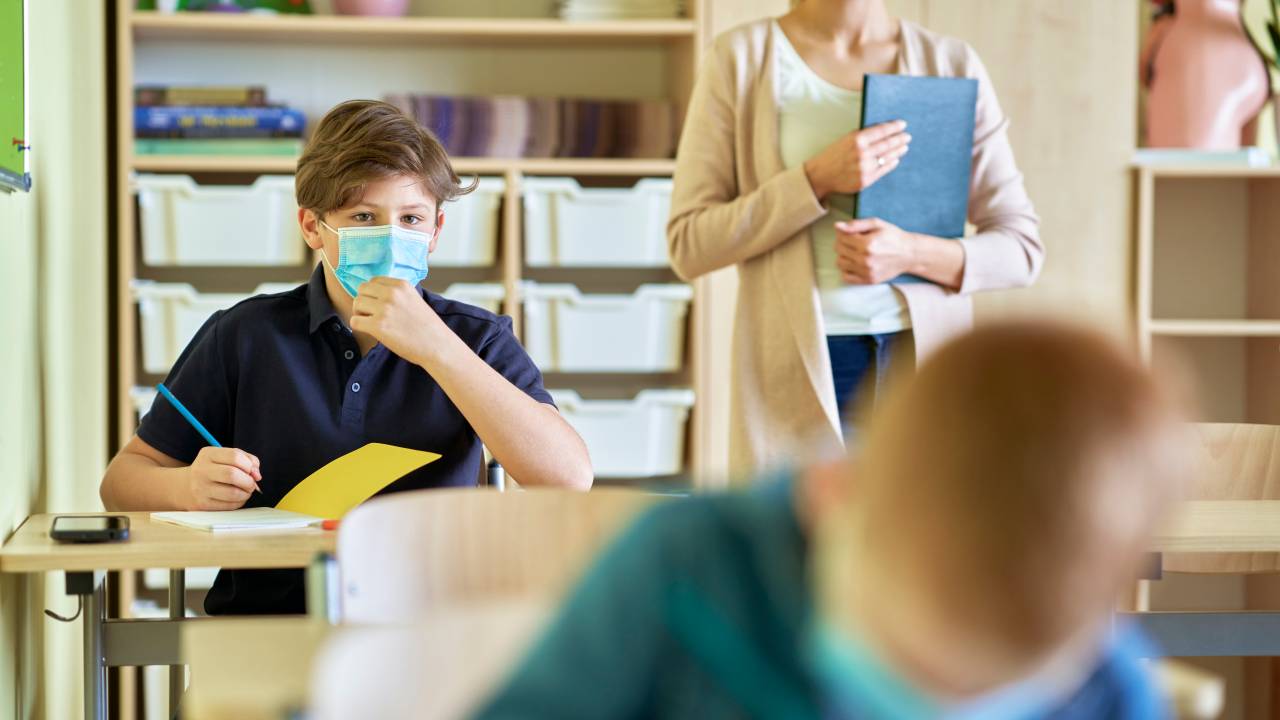 Crianças de máscara na sala de aula.