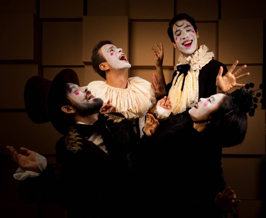 Foto mostra grupo de atores rindo com as caras pintadas de branco e roupas antigas