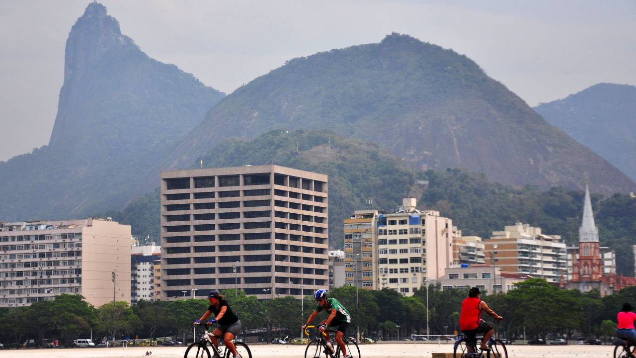 Imagem mostra ciclistas andando de bike na Praia de Botafogo