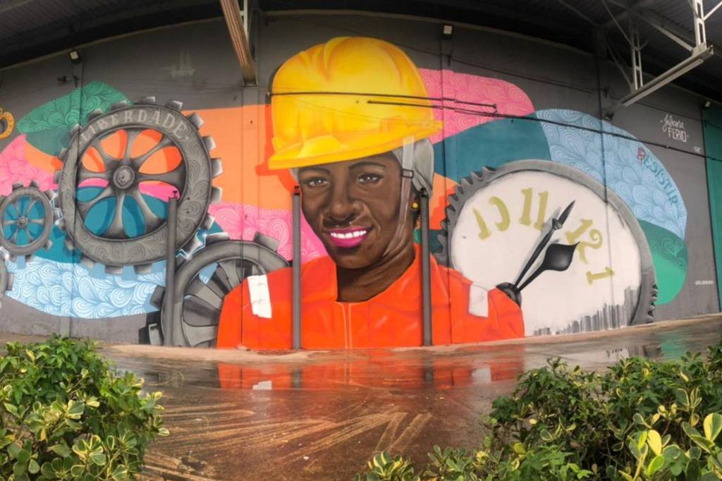 Arte em grafite mostra uma mulher negra que trabalha no setor petrolífero.