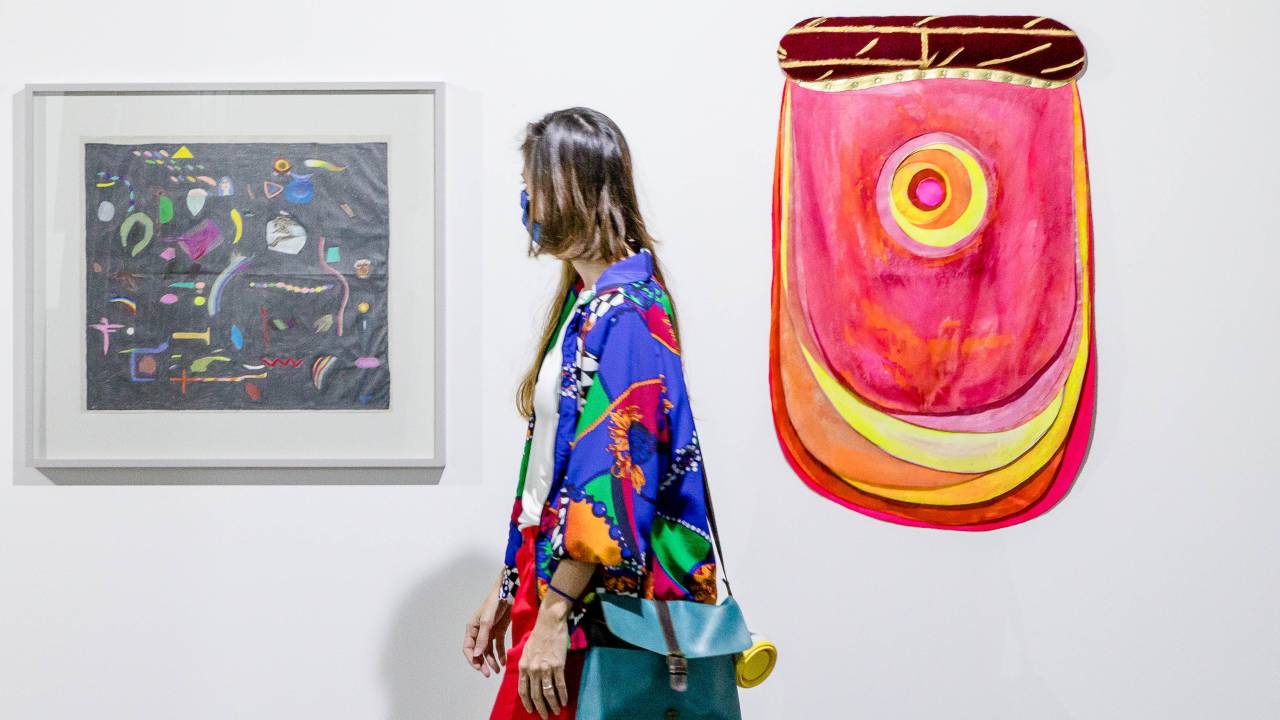 Mulher passa ao lado de duas obras de arte na ArtRio