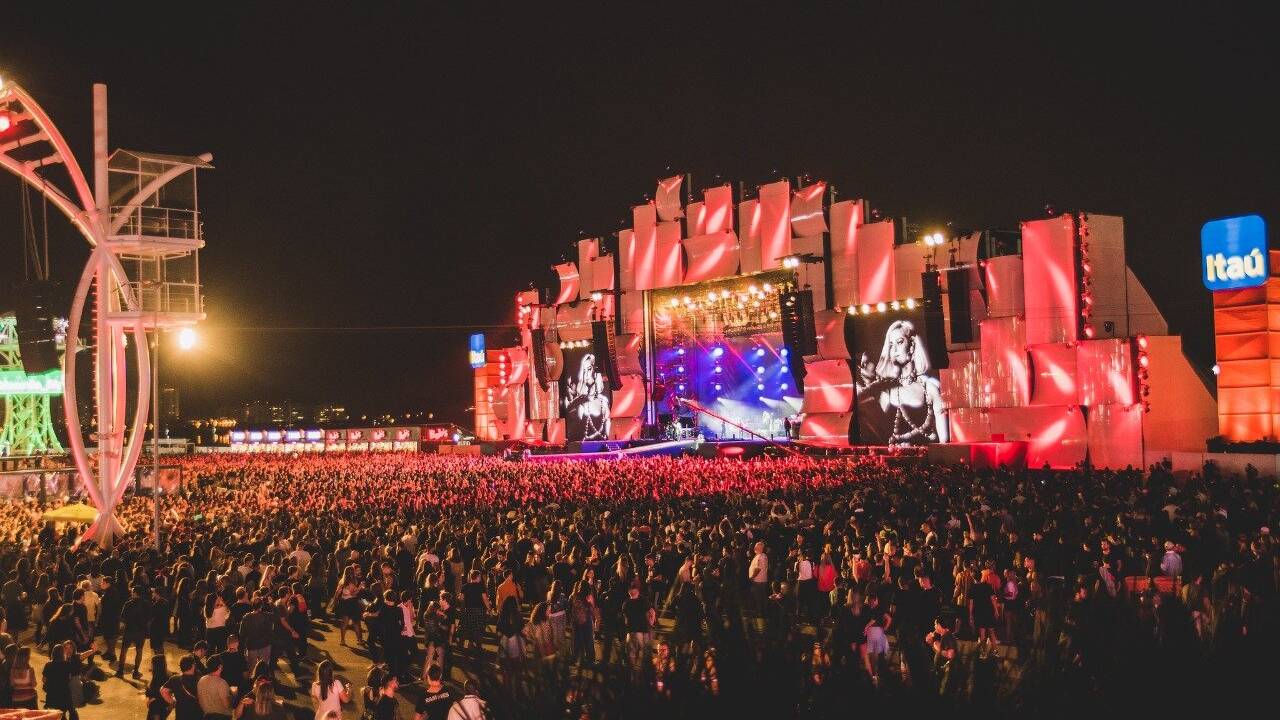 Uma multisão assiste a um show com iluminação vermelha no Palco Mundo do Rock in Rio