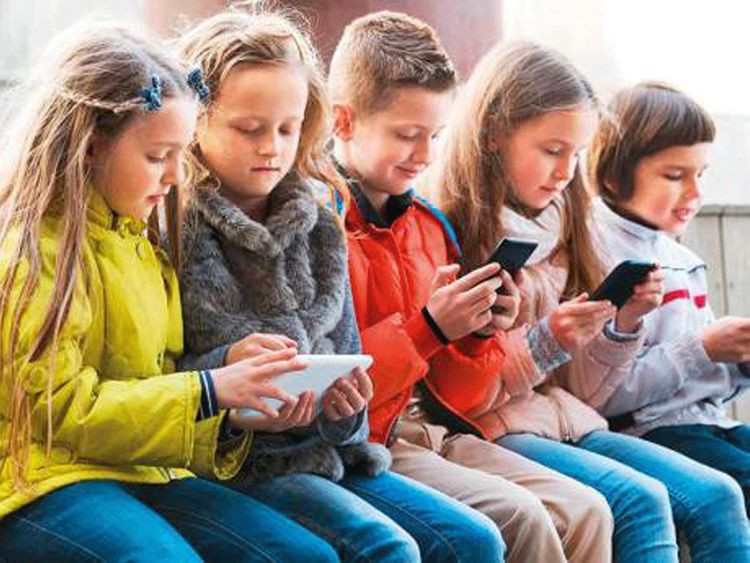 Crianças usando celulares.