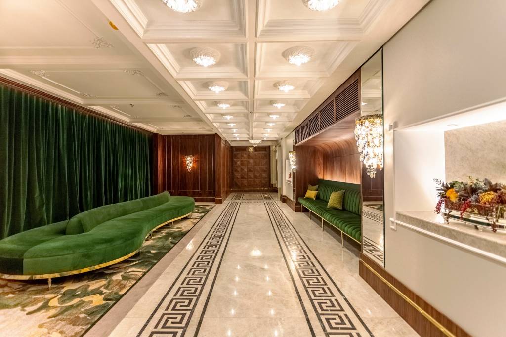 Foyer do Teatro Copacabana Palace, com lustres e sofá de veludo verde