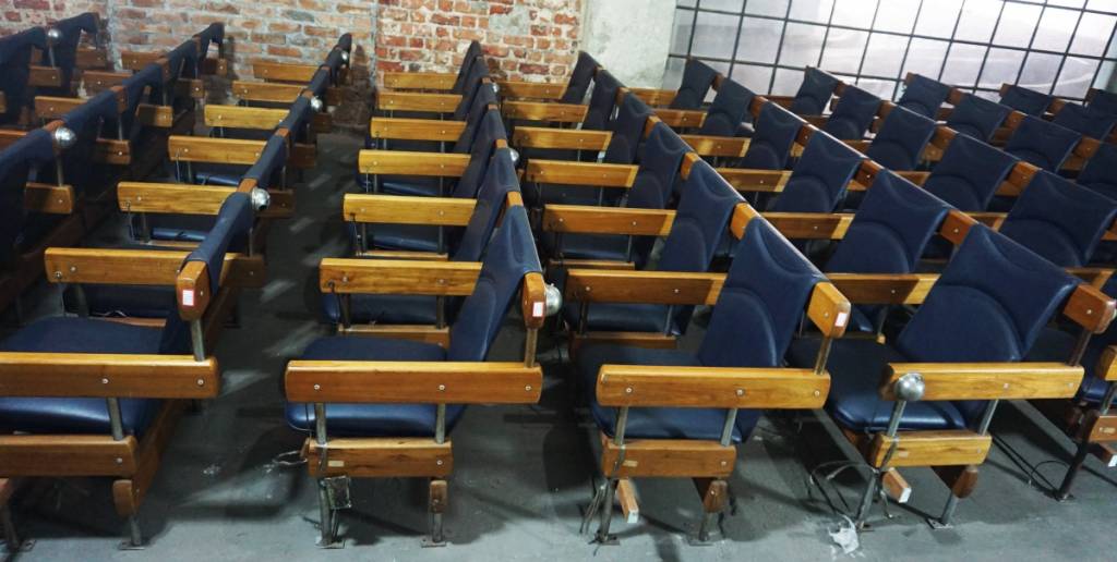 Auditorio com cadeiras de madeira e couro