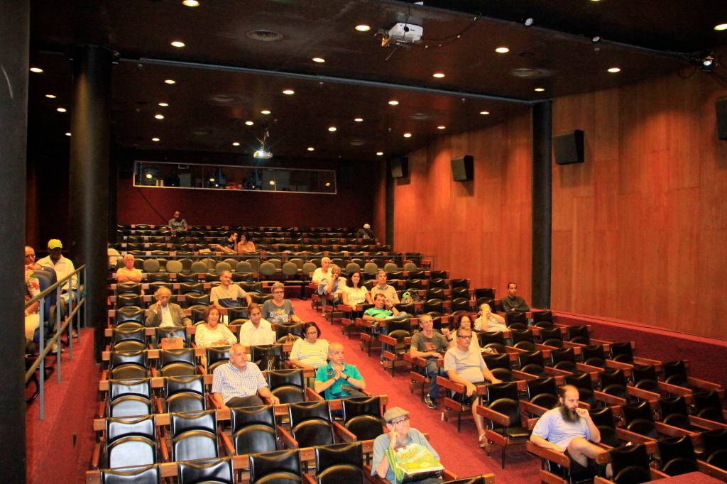 Foto da sala de cinema da Cinemateca do MAM com algumas pessoas nas poltronas