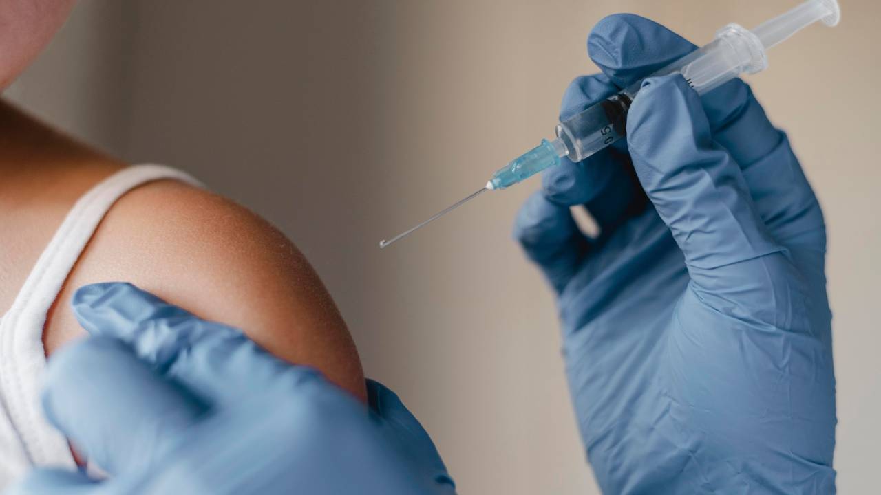 Foto mostra criança tomando vacina
