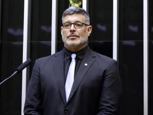 Foto do deputado Alexandre Frota de terno e camisa pretos e gravata branca