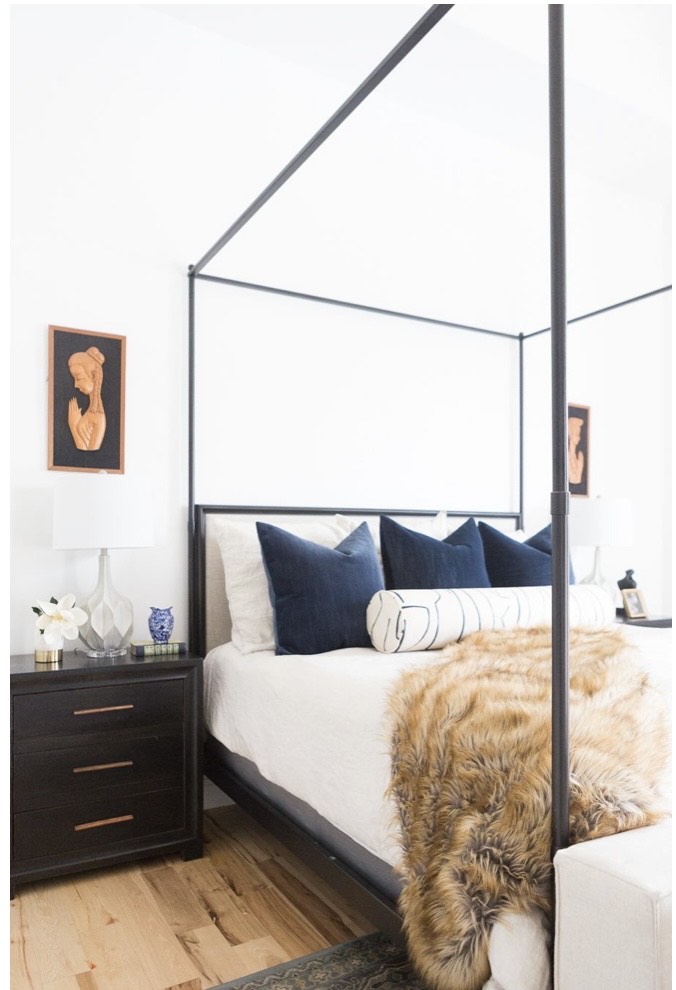 A imagem mostra um quarto com uma cama com dossel sem tecido