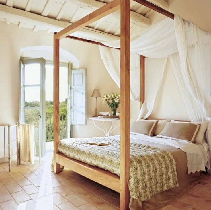 A imagem mostra um quarto com uma cama com dossel e tecido