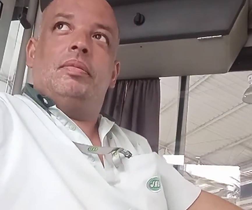 A imagem mostra Leandro Miranda sentado no banco de motorista do ônibus