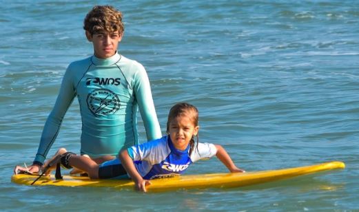 Foto mostra crianças surfando