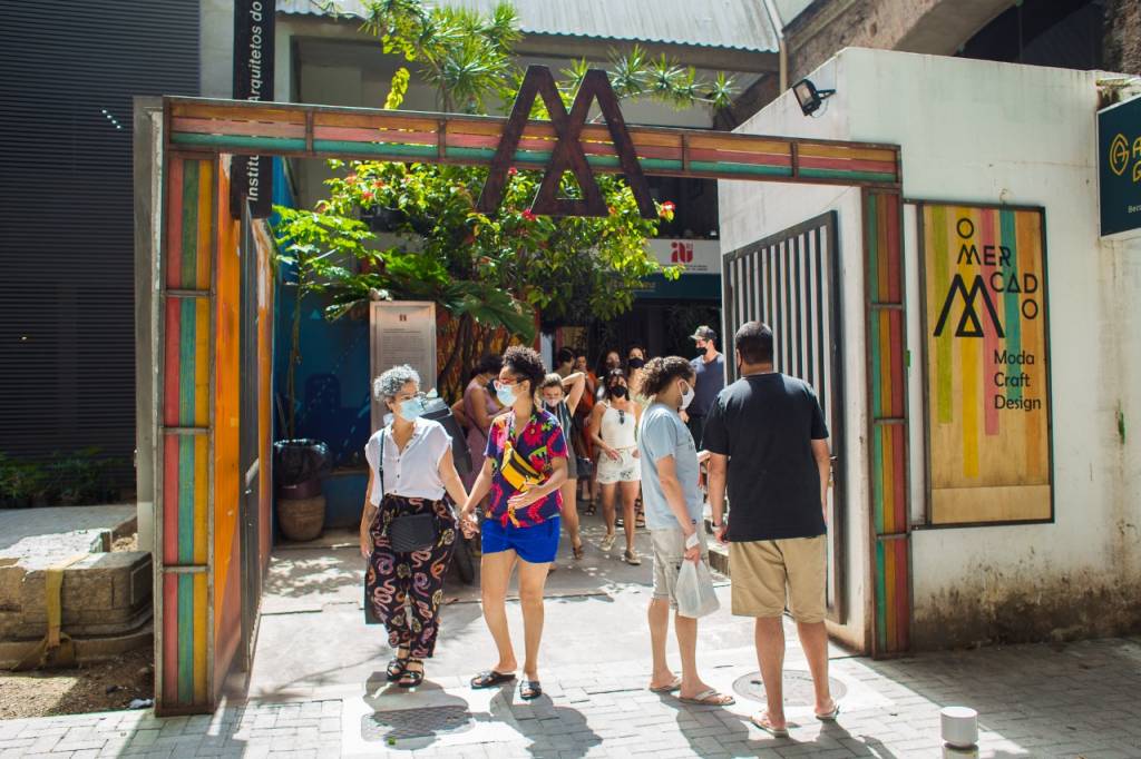 Foto mostra pessoas entrando em feira