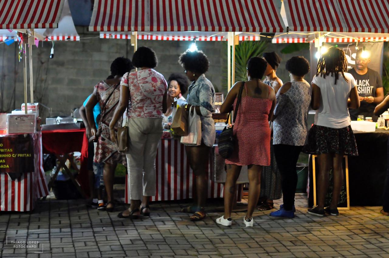 Foto mostra mulheres negras comprando em feira