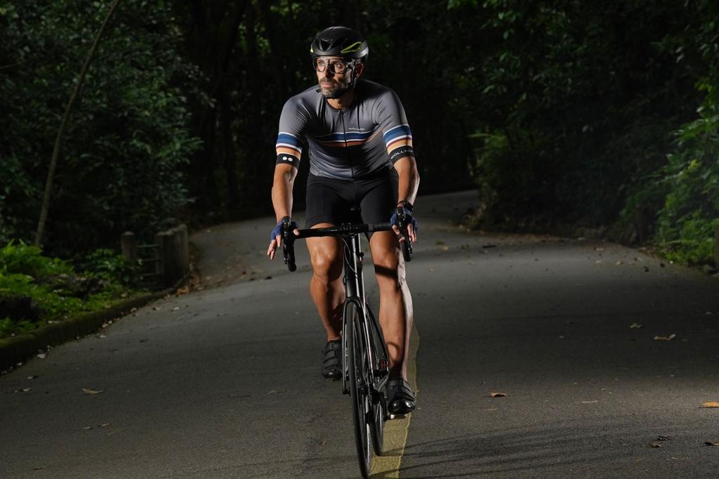 Foto mostra ciclista andando de bike à noite