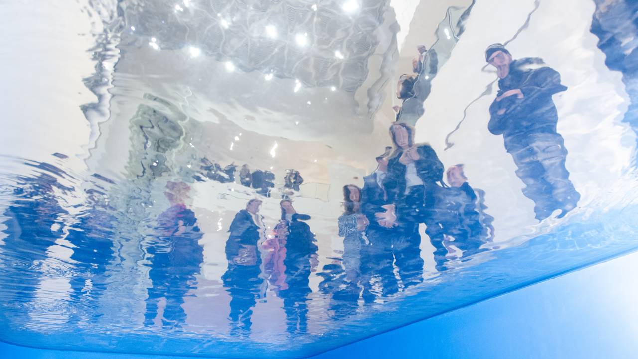 Instalação ilusionista que é uma piscina em que o público pode observar de dois lugares, vista do ponto de vista de quem está embaixo do espelho d'água