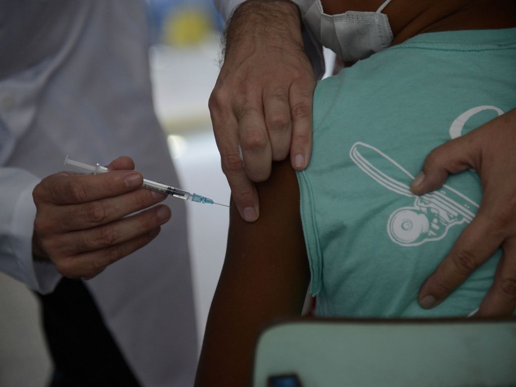 Foto mostra criança recebendo vacina