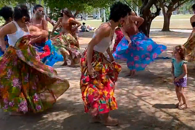 Foto mostra mulheres dançando carimbó com roupas coloridas