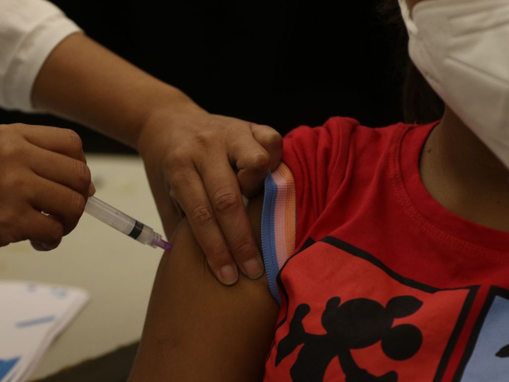 Foto mostra criança sendo vacinada contra a Covid-19